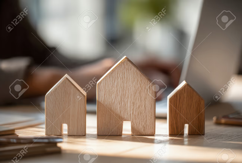 Three wooden house models on a desk