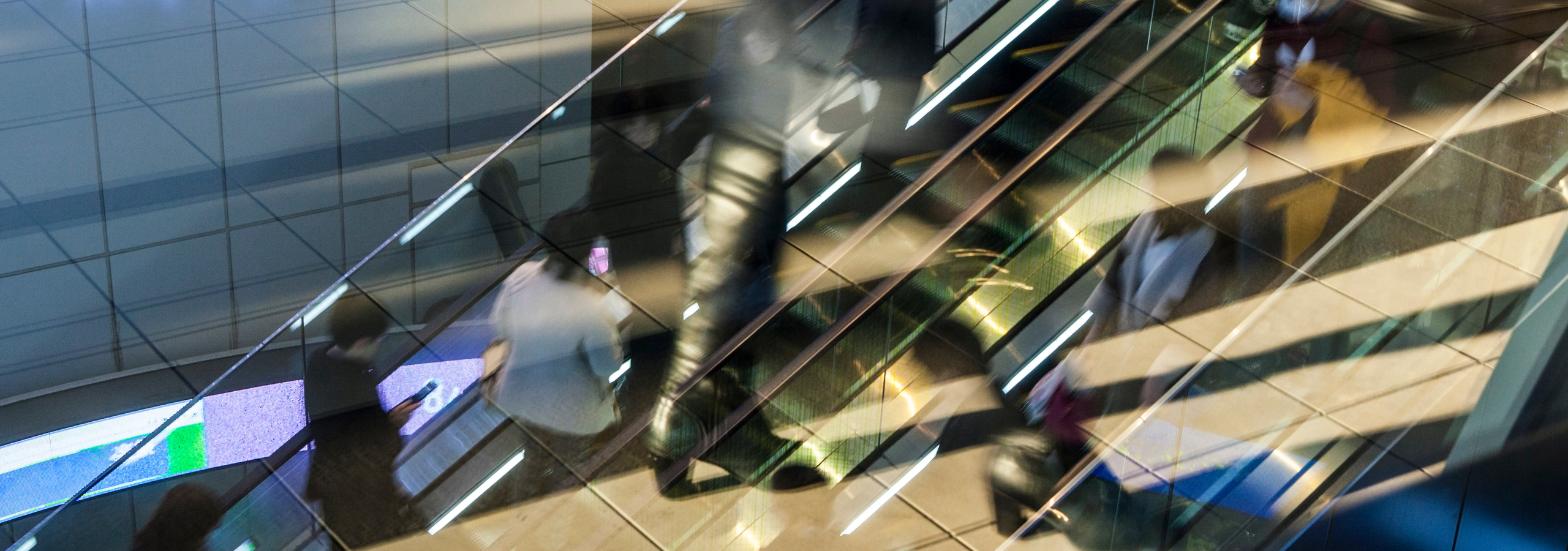 Glass staircase and escalators inside PriceSanond's Q House Lumpini office building