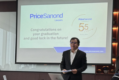 A speaker standing in front of a projector screen displaying PriceSanond's congratulatory graduation message to interns.